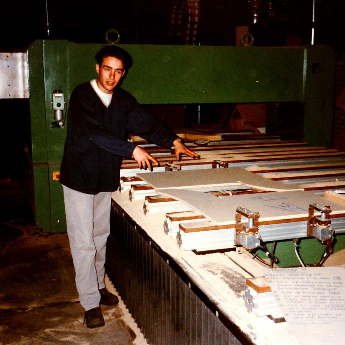 Foto van vroeger waarbij de directeur uitleg geeft bij een CNC machine